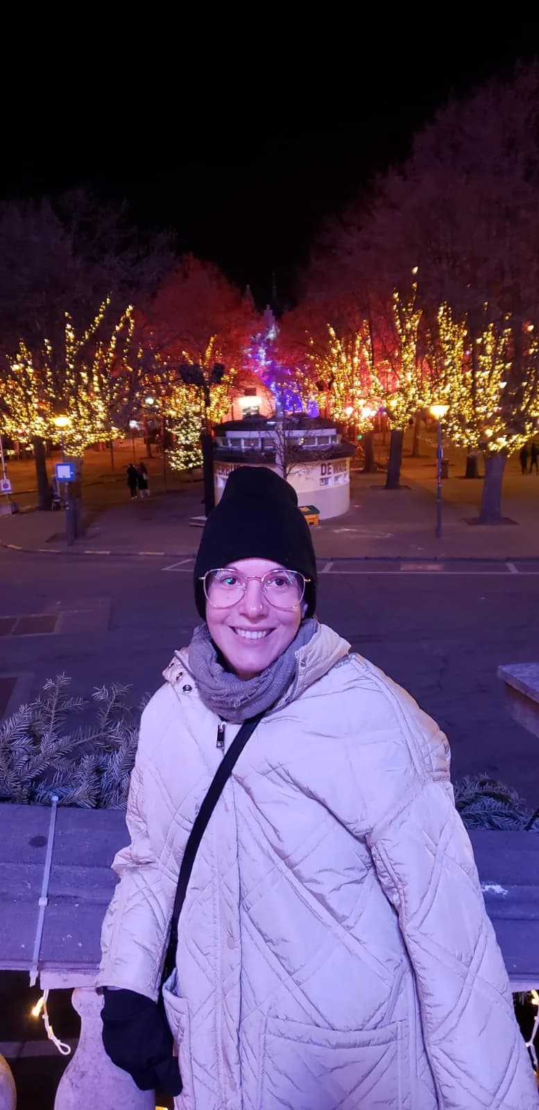 Laís em uma praça com luzes de Natal europeias, Bélgica